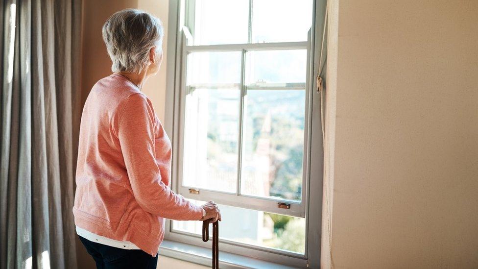 Older woman looking out of the window