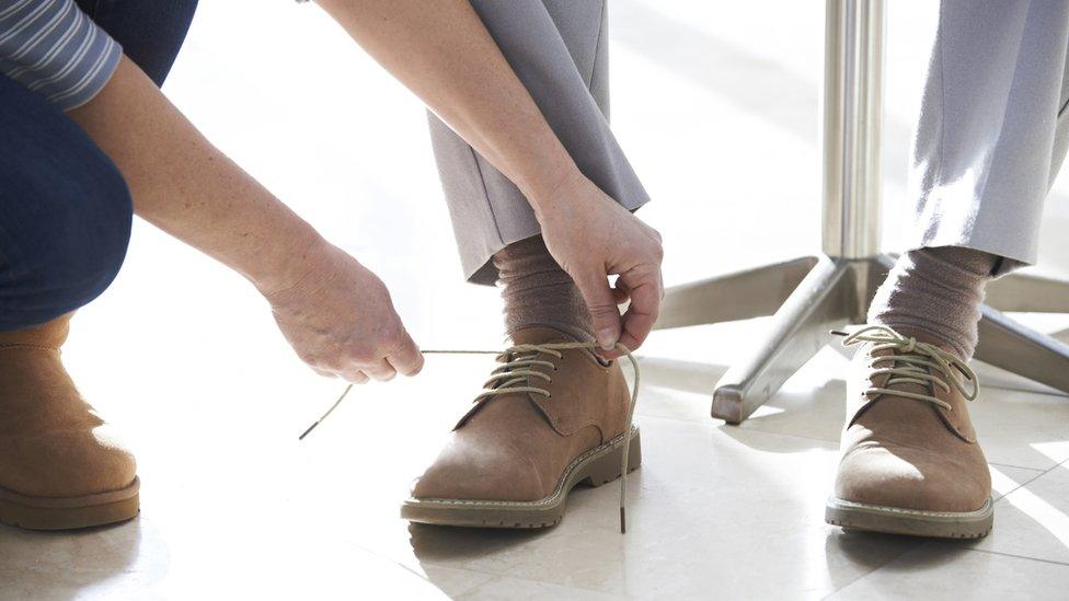 A person's shoe being tied