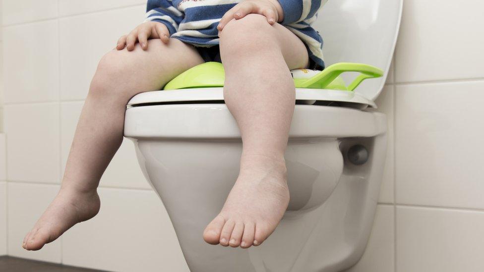 A file picture showing the legs of a toddler sitting on a toilet