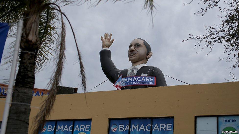 A sign waves from the top of insurance co. roof advertising for the Affordable Care Act, also known as Obamacare, as the company tries to sign people up before the February 15th deadline on February 5, 2015 in Miami,