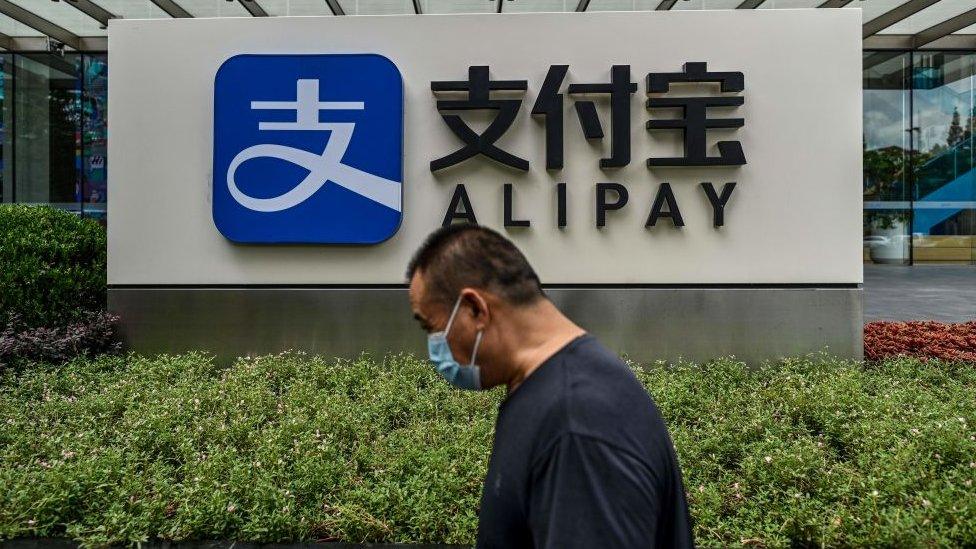 A man walks past an Alipay sign outside Ant Group's building in Shanghai.