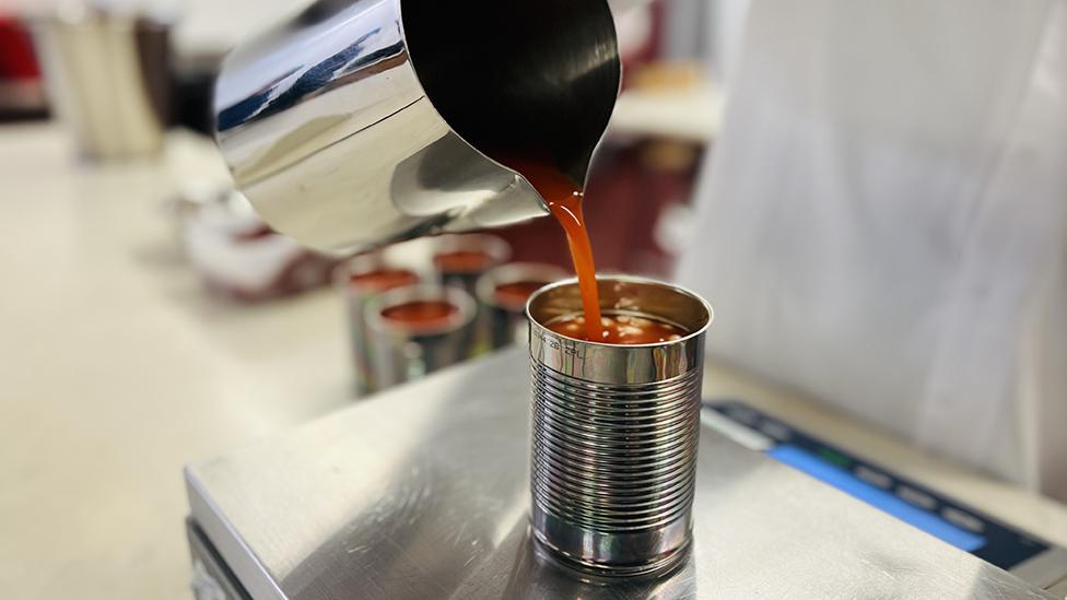 Beans being poured into tin