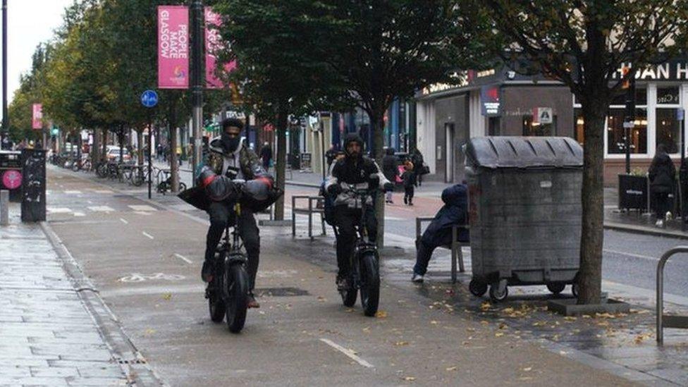 A courier on an e-bike overtaking another e-bike