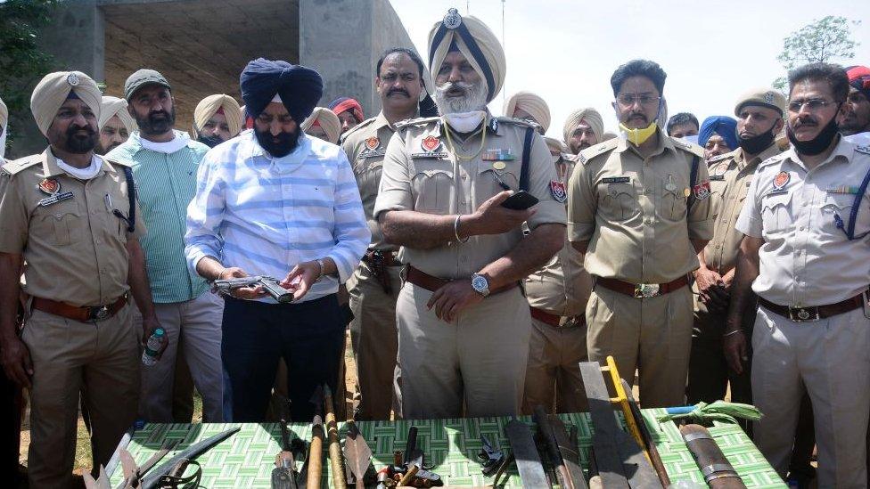 Police officers show sharp-edged weapons recovered from the arrested Nihangs in Punjab in India