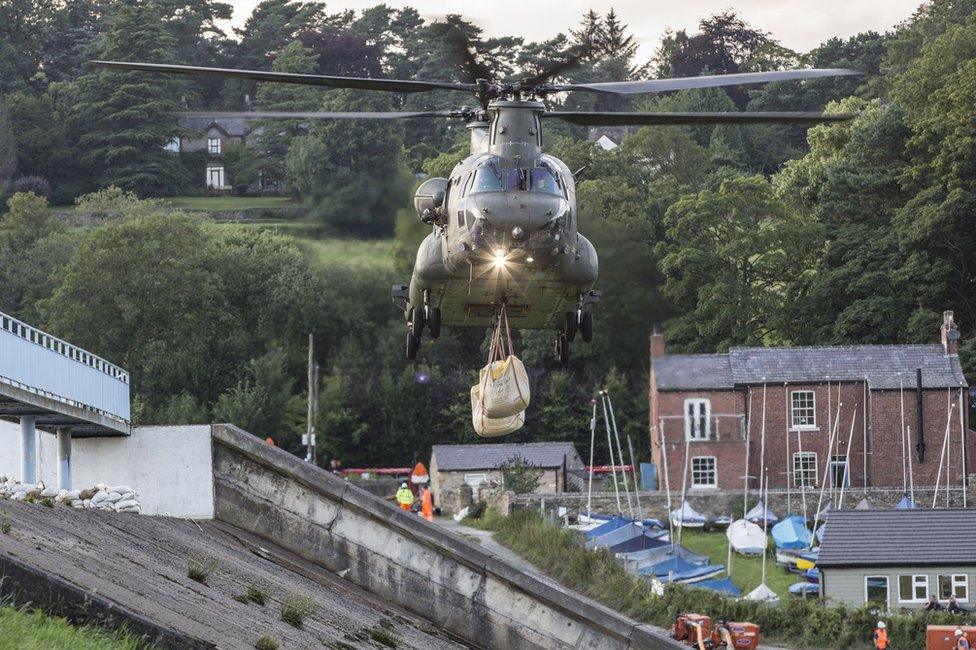 Chinook helicopter approaches with the load to drop on the dam in Whaley Bridge