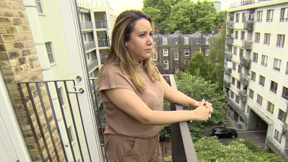 Juliana Terlizzi, a woman with dark hair wearing light brown clothes, stood looking out from a balcony