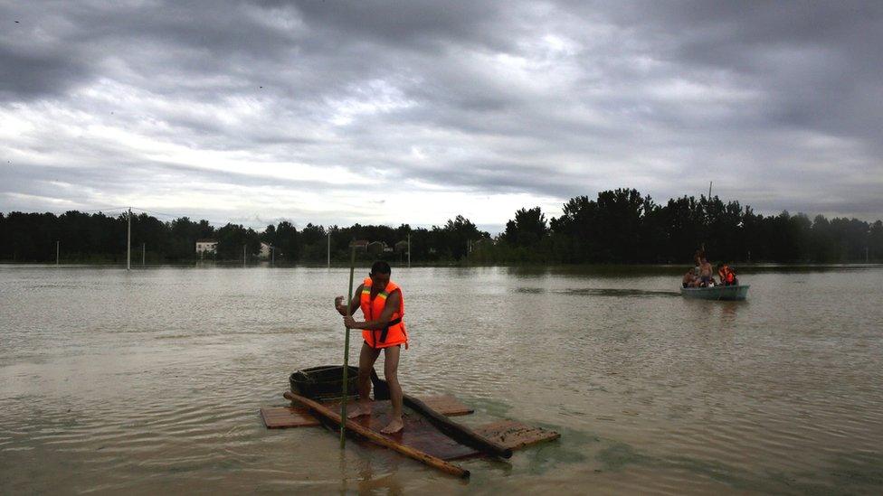 The villagers rowing in the flood after Jushui River broke the dyke and flooded XuJiaDun village in Wuhan in central China's Hubei province Saturday