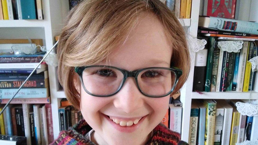 Image of a girl smiling in glasses with short hair