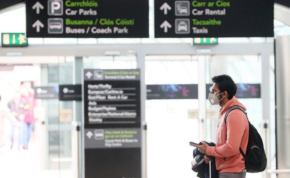 A man wearing a facemask in the arrivals hall at Dublin Airport