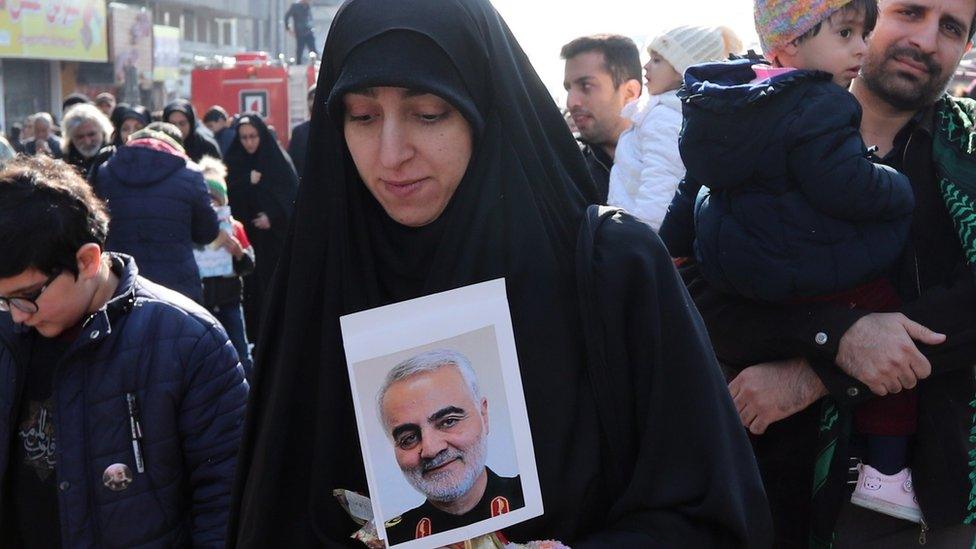 An Iranian woman holds a picture of Iranian Revolutionary Guards Corps Lieutenant General Qasem Soleimani during a funeral ceremony in Tehran, 6 January 2020