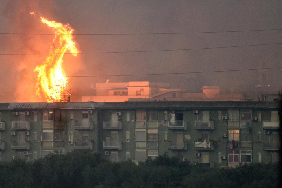 A wildfire burns on the hills surrounding the town of Ciaculli, near Palermo, Italy