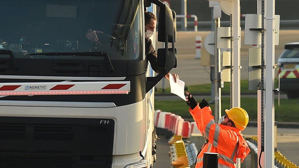 A driver hands out documents for checking at the 'pit stop' for documentation checks before heading to passport control at the Eurotunnel terminal at Folkestone, Southeast England