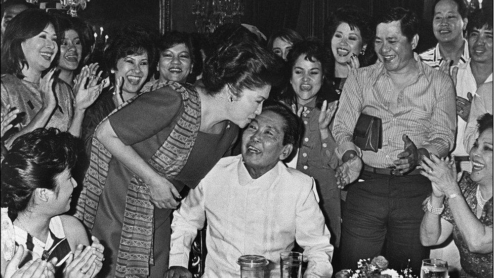 Photo dated 16 February 1986 shows late Philippine President Ferdinand Marcos (C) receiving a kiss from his wife Imelda following his victory of the 07 February 1986 presidential elections, at Malacanang presidential palace in Manila.