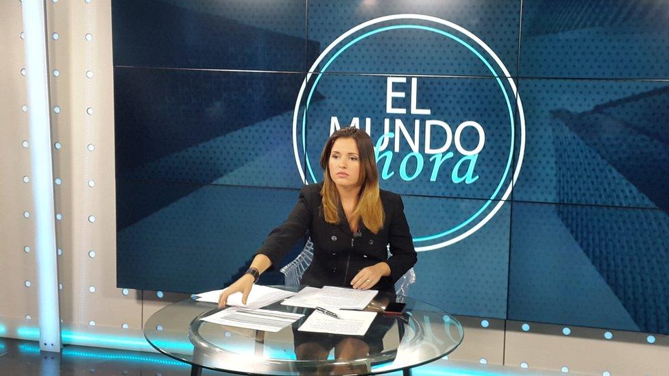 A presenter sits on the set of Canal Caribe's El Mundo ahora