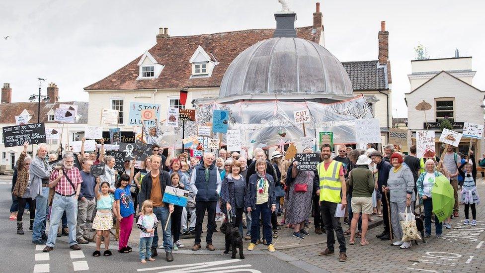 Protestors at a Procession Against Poo in Bungay, Suffolk, holding placards