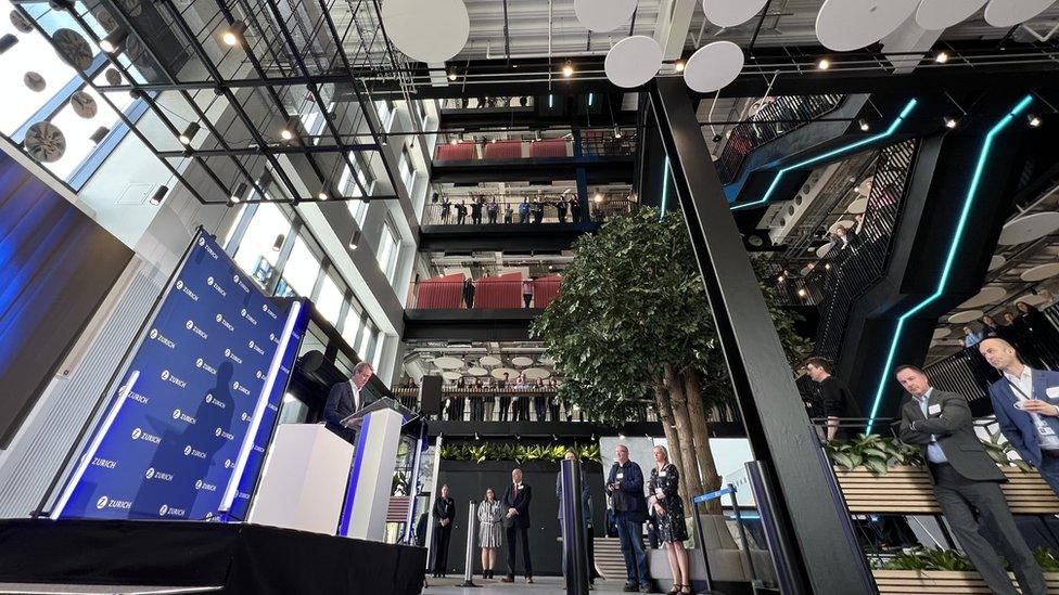 Inside of Zurich building showing indoor tree and plans in boxes