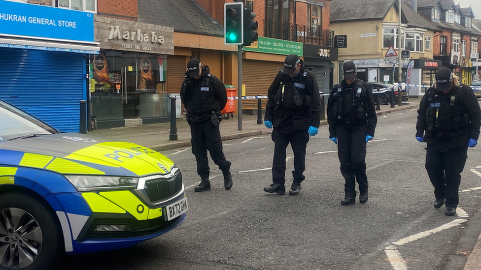 Police officers searching the road