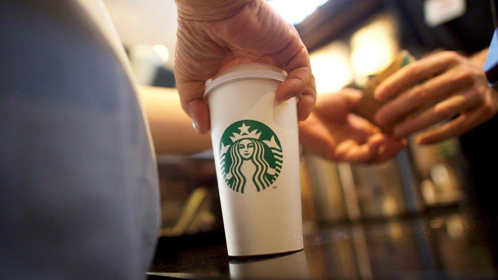 A Starbucks customer takes her coffee at a store