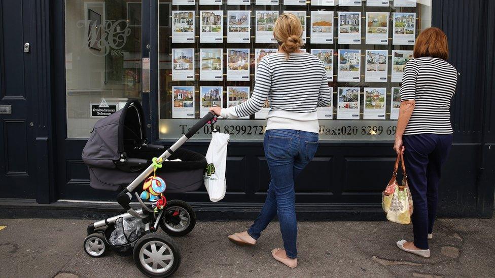 women looking in estate agent window