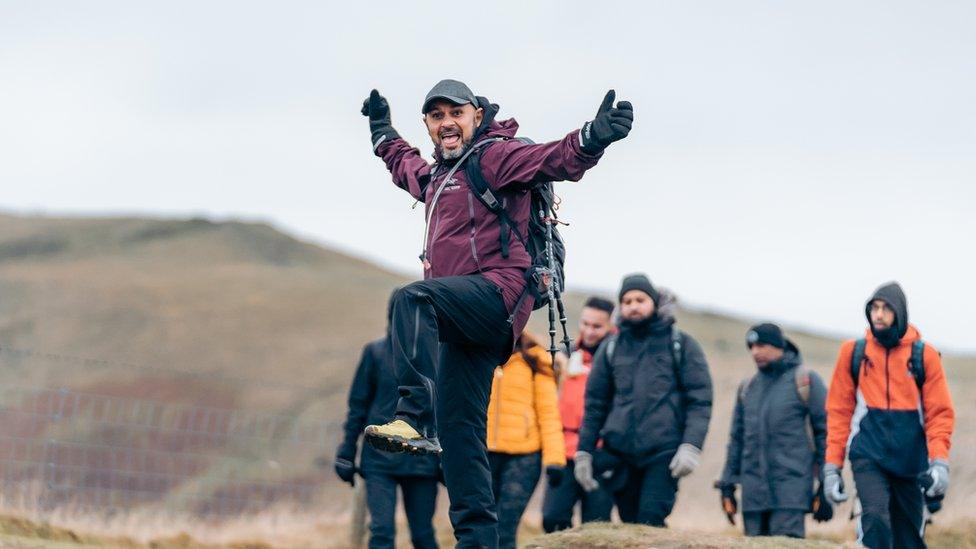 A man on a hike posing for a picture