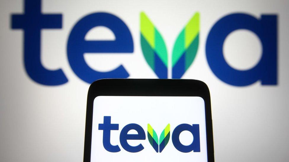 In this photo illustration, a Teva logo of an Israel pharmaceutical company seen displayed on a smartphone and a pc screen