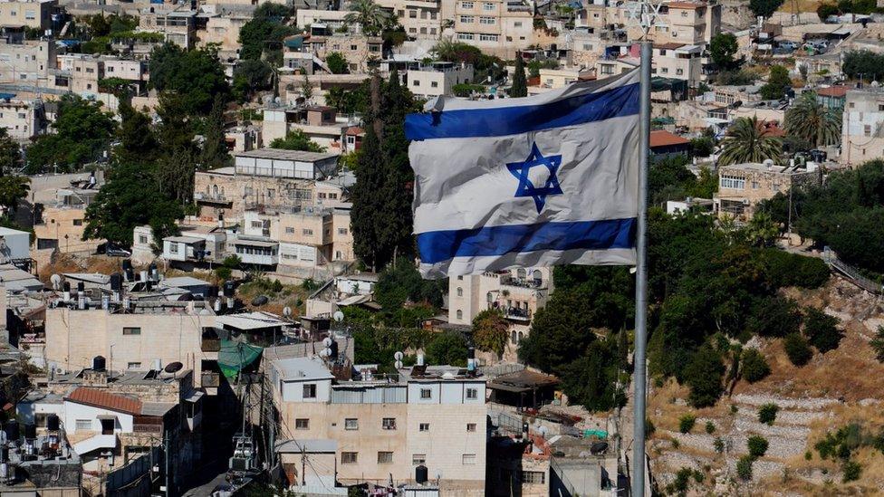 An Israeli flag flies above East Jerusalem's Sheikh Jarrah neighbourhood