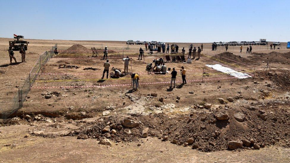 Iraqi forensic personnel exhumes bodies at a mass grave where inmates of Badoush prison were killed by the Islamic State group, in al-Humaydat village, western Mosul, Iraq (13 June 2021)