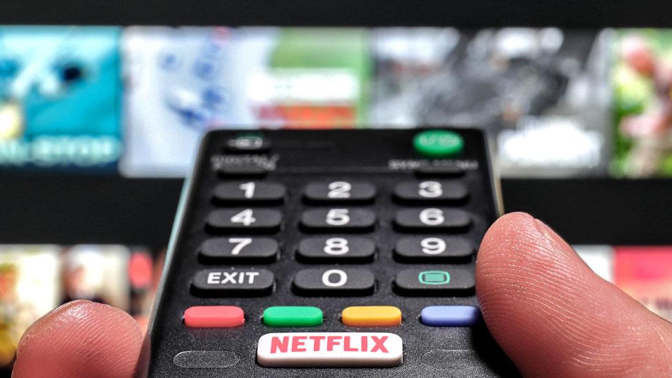 Stock image of TV remote control and the Netflix screen