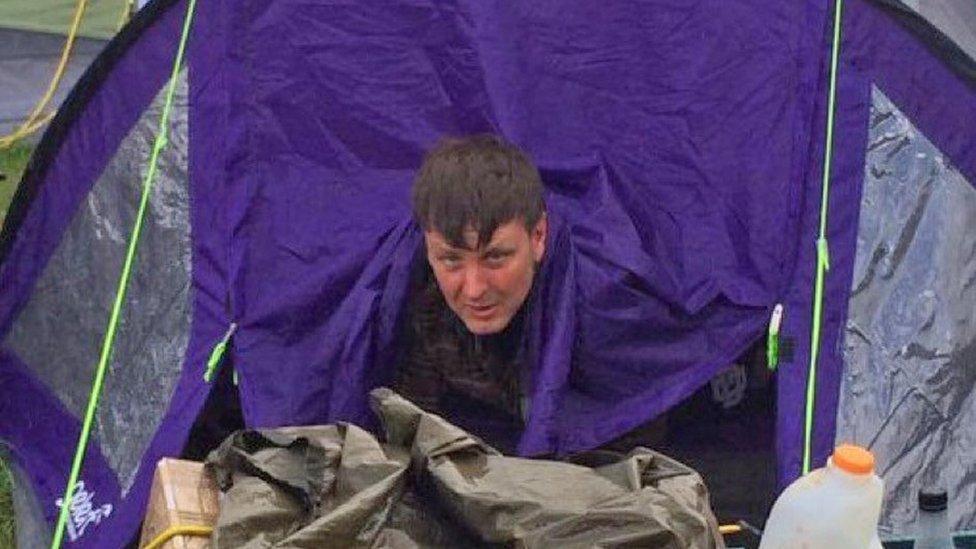 Nigel Stonehouse emerges from a tent