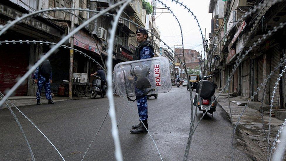 Rapid Action Force personnel stand guard at a roadblock ahead of the Muslim Friday noon prayers in Jammu on August 9, 2019, after the Indian government stripped Jammu and Kashmir of its autonomy