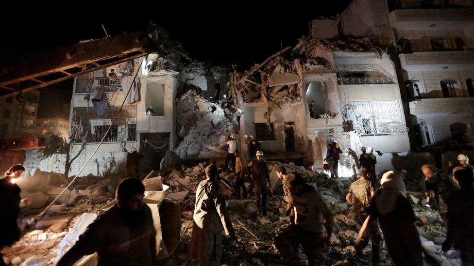 Civilians and civil defence members look for survivors at a site damaged after air strikes on the Syrian rebel-held city of Idlib