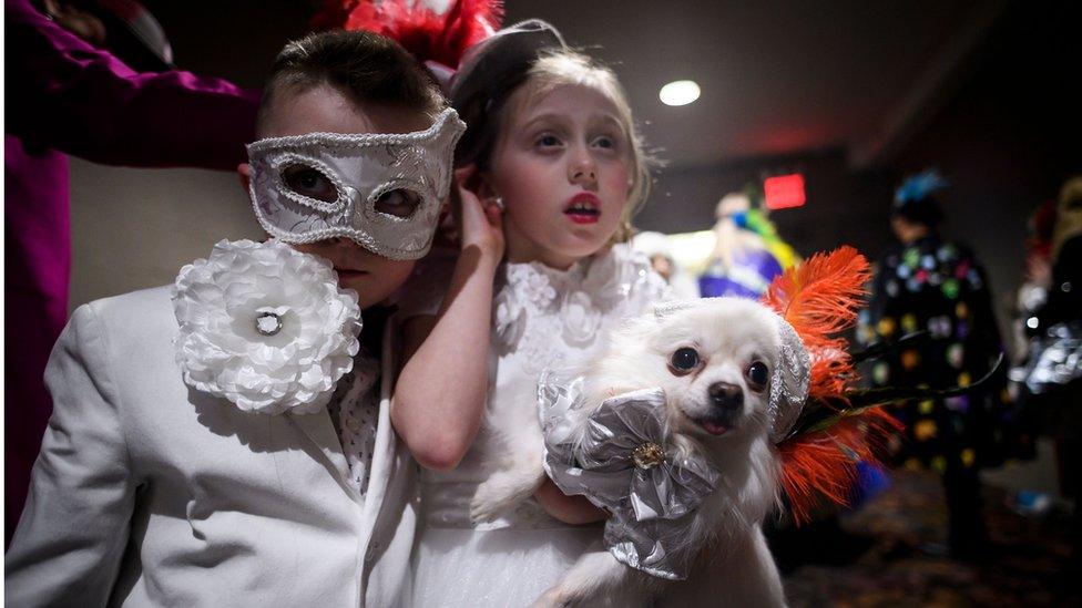 Two children dressed in white with their lovely little dog