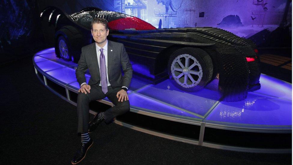 Artist Nathan Sawaya poses with a model of the Batmobile