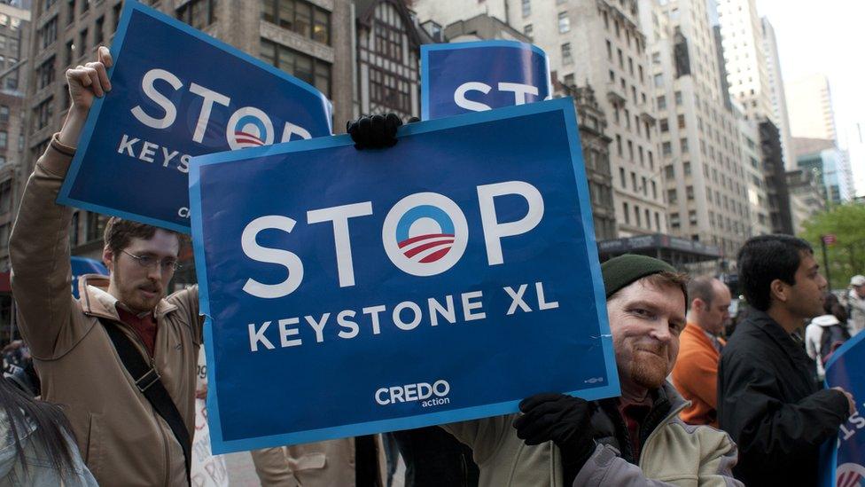 Protestors hold up "stop Keystone XL" signs.