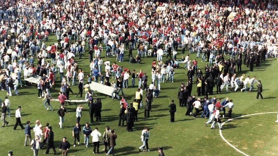 Hillsborough spectators run with makeshift stretchers on pitch