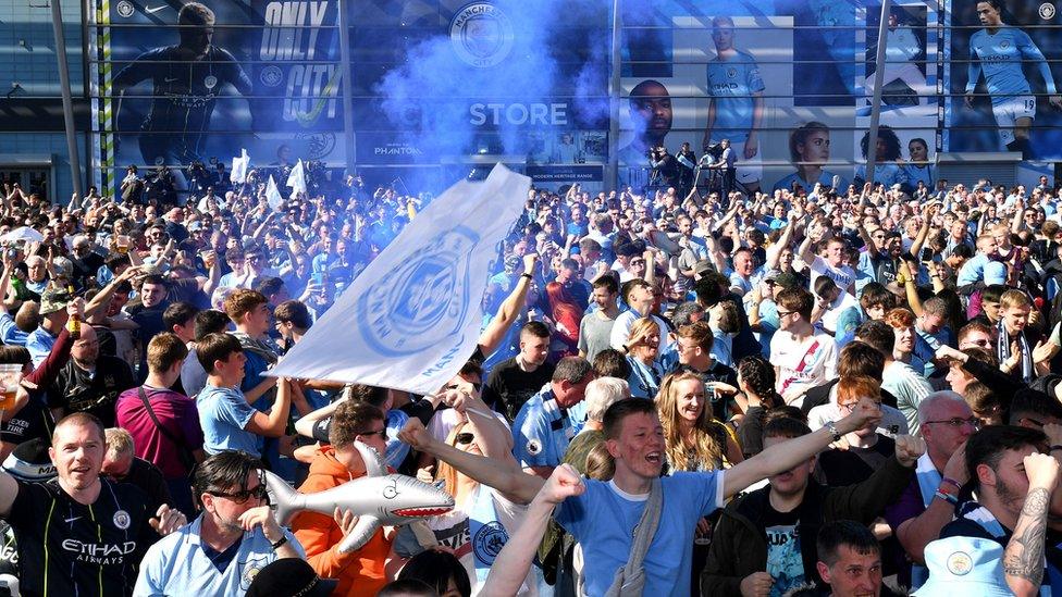 City fans celebrate and let off a blue flare