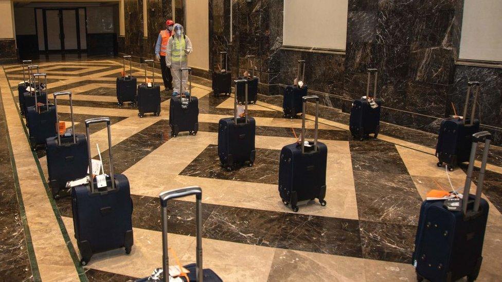 Workers sanitising pilgrims' luggage in a hotel lobby located near the Grand Mosque in Saudi Arabia's holy city of Mecca, during the annual hajj pilgrimage amid the coronavirus crisis