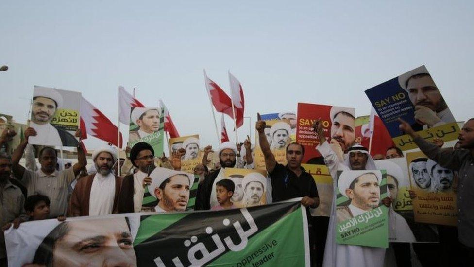 Men and boys chant slogans and raise national flags and posters of Sheikh Ali Salman during a protest in Bahrain on 16 June 2015