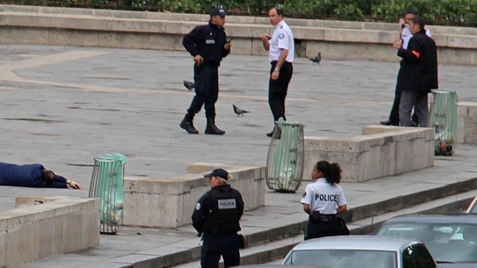 Police officers stand near a wounded attacker (at left) after a shooting incident near Notre-Dame cathedral in Paris, France (June 6, 2017)