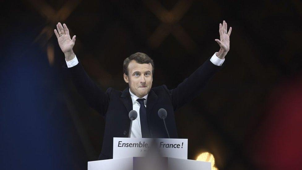 Emmanuel Macron greets supporters as he arrives to deliver a speech in front of the Pyramid at the Louvre Museum