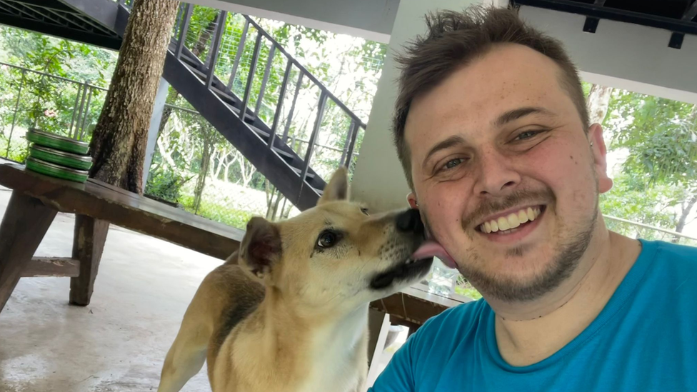 Robert Bays of Battersea, being licked by a dog