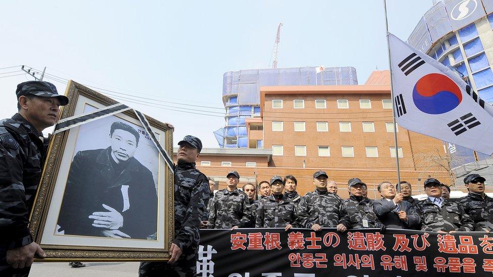 South Korean veterans hold a framed portrait Ahn Jung-Geun during a rally marking the 100th anniversary of his death