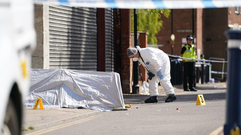 A forensic investigator searches the area