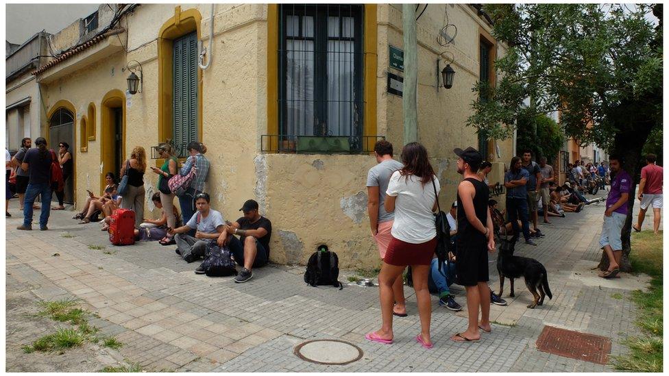 Customers queue outside a pharmacy to buy weed