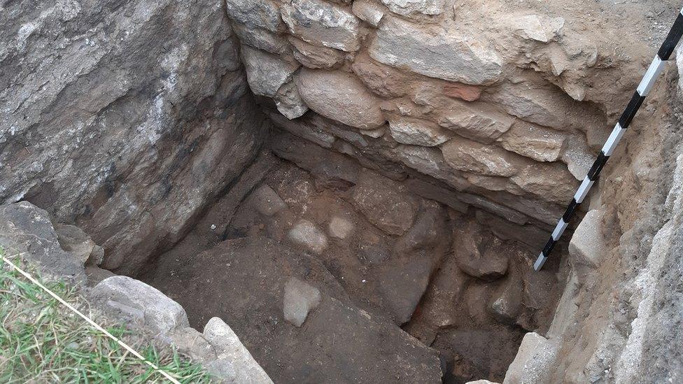 Roman courtyard visible at bottom of trench