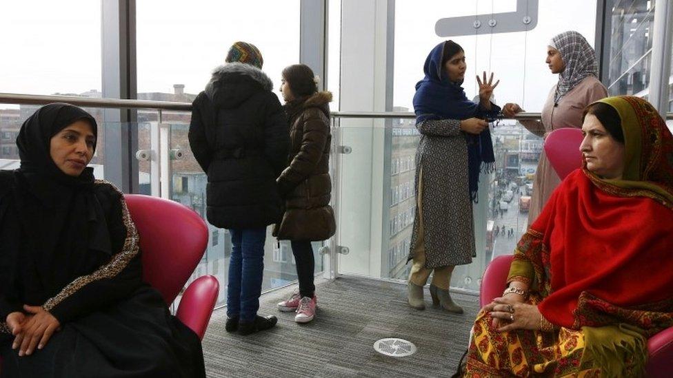 Malala Yousafzai (3rd on the right) speaks to 17-year-old Syrian refugee Muzoon Almellehan as their mothers Eman Almellehan (left) and Torpekai Yousafzai (right) speak at the City Library in Newcastle Upon Tyne (22 December 201)