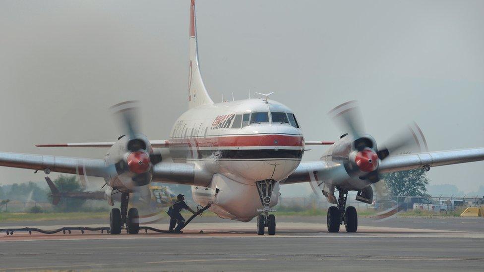 A ground crew fills a Conair airtanker with fire retardant at the Provincial Wildfire Coordination Centre at Kamloops Airport