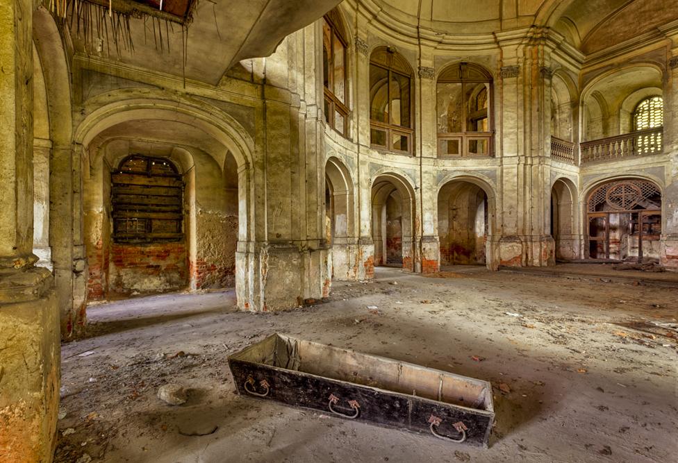 Empty coffin in large room