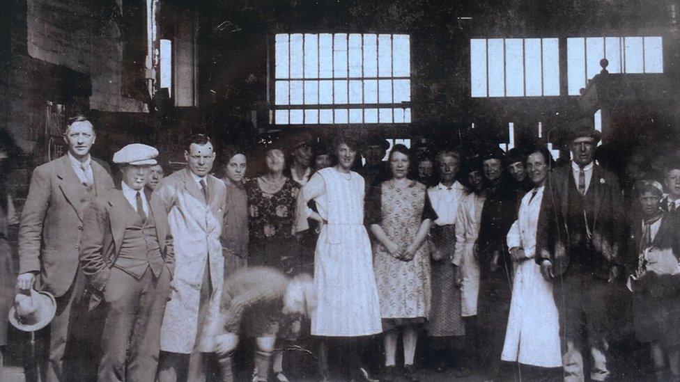 A dozen people pose for a picture at the market