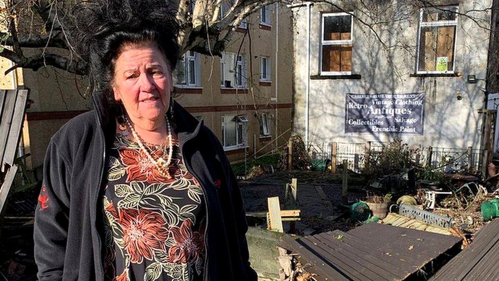 Gaynor Lloyd standing in front of flood damage